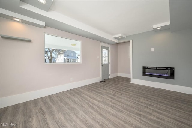 unfurnished living room featuring a healthy amount of sunlight and hardwood / wood-style floors