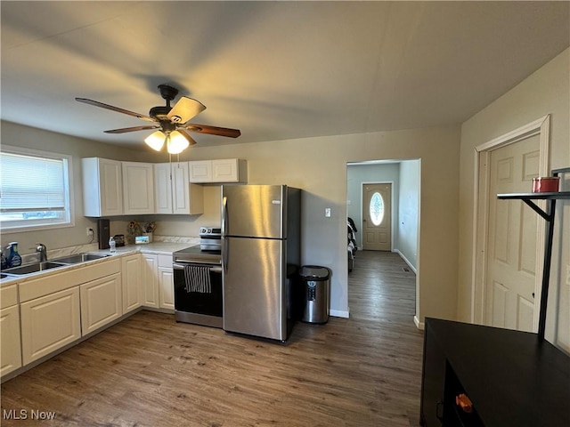 kitchen with white cabinetry, sink, light hardwood / wood-style flooring, and appliances with stainless steel finishes