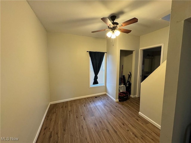 empty room featuring ceiling fan and dark hardwood / wood-style flooring