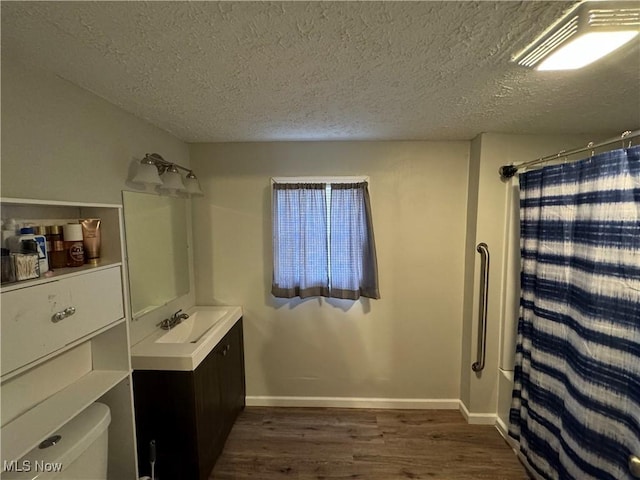 bathroom with wood-type flooring, vanity, toilet, a textured ceiling, and a shower with shower curtain