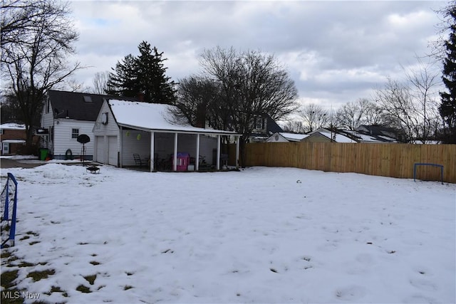 yard covered in snow featuring fence and an outdoor structure