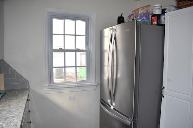 kitchen featuring white cabinetry and stainless steel fridge