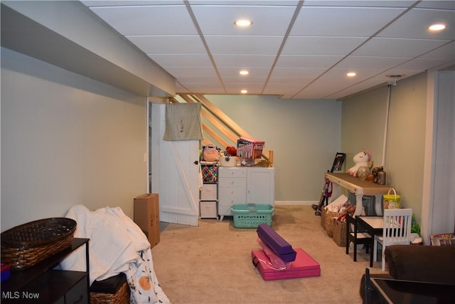 playroom featuring light carpet and a drop ceiling