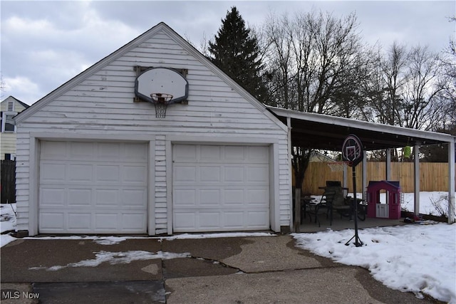 snow covered garage featuring a carport