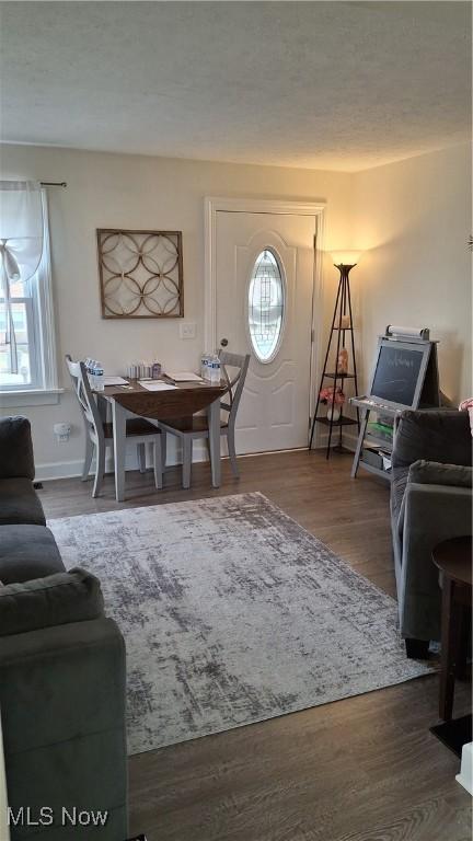 entryway featuring a textured ceiling, wood finished floors, and baseboards