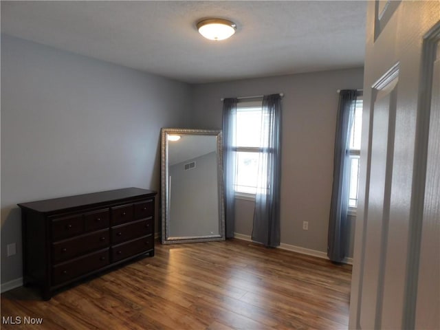 unfurnished bedroom with dark wood-type flooring