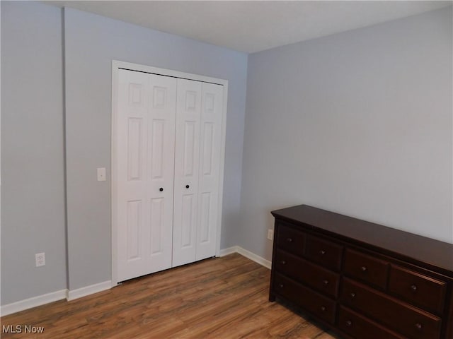 bedroom with wood-type flooring and a closet