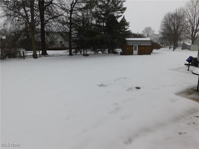 snowy yard with an outbuilding