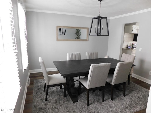 dining space with ornamental molding, a notable chandelier, and dark hardwood / wood-style flooring