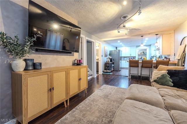 living room with dark hardwood / wood-style floors and a textured ceiling