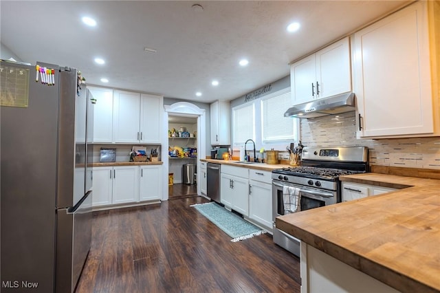 kitchen with white cabinetry, appliances with stainless steel finishes, sink, and wood counters