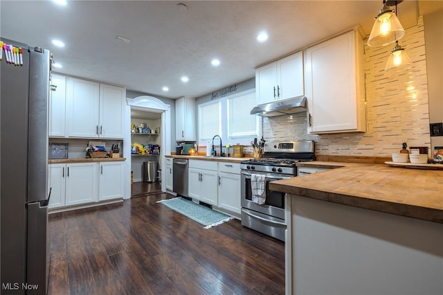 kitchen featuring butcher block counters, stainless steel appliances, and white cabinets