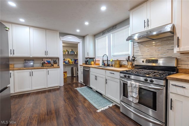 kitchen featuring stainless steel appliances, white cabinets, and wooden counters