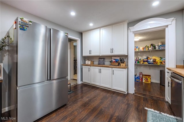 kitchen featuring appliances with stainless steel finishes, dark hardwood / wood-style flooring, butcher block countertops, and white cabinets