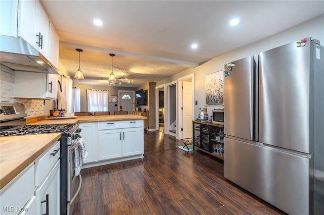 kitchen featuring wooden counters, white cabinets, hanging light fixtures, stainless steel appliances, and dark wood-type flooring