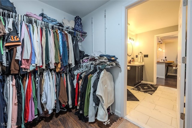 walk in closet featuring hardwood / wood-style flooring and sink