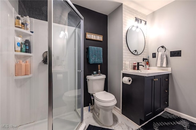 bathroom featuring toilet, vanity, backsplash, and a shower with shower door