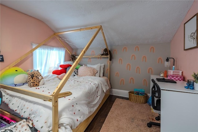 bedroom featuring lofted ceiling, dark wood-type flooring, and a textured ceiling