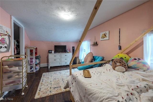 bedroom featuring dark hardwood / wood-style flooring, vaulted ceiling, and a textured ceiling