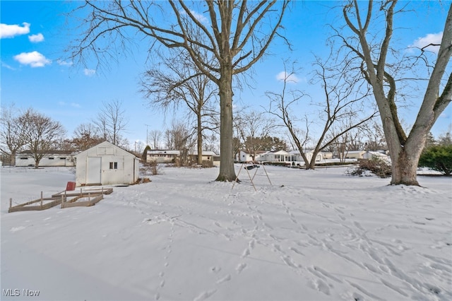 snowy yard with a storage unit