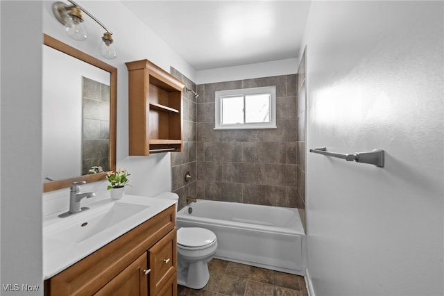 full bathroom featuring tiled shower / bath combo, vanity, and toilet