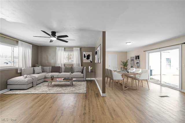 living room with light hardwood / wood-style floors and ceiling fan