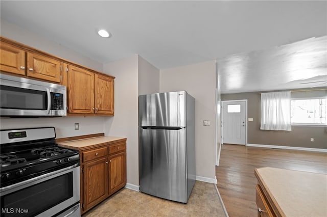 kitchen with appliances with stainless steel finishes and light hardwood / wood-style flooring