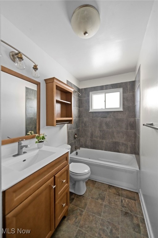 full bathroom featuring vanity, tiled shower / bath combo, and toilet