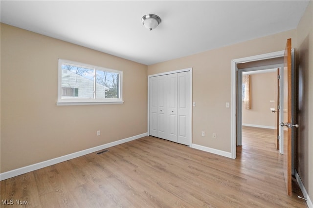 unfurnished bedroom with a closet and light hardwood / wood-style flooring