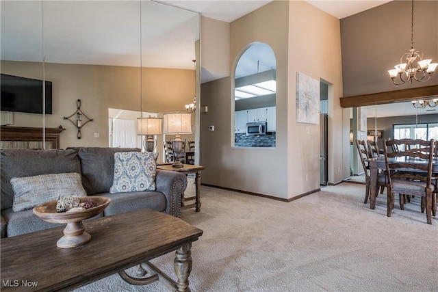 4539 Saint James Cir NW, Canton, OH 44708 - living room featuring a towering ceiling, light colored carpet, and a notable chandelier