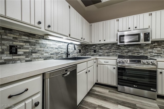 4539 Saint James Cir NW, Canton, OH 44708 - kitchen featuring sink, white cabinetry, backsplash, stainless steel appliances, and wood-type flooring
