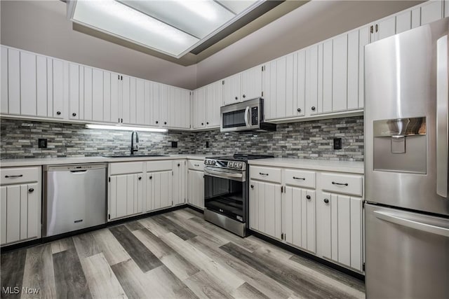 4539 Saint James Cir NW, Canton, OH 44708 - kitchen with sink, light hardwood / wood-style flooring, backsplash, stainless steel appliances, and white cabinets