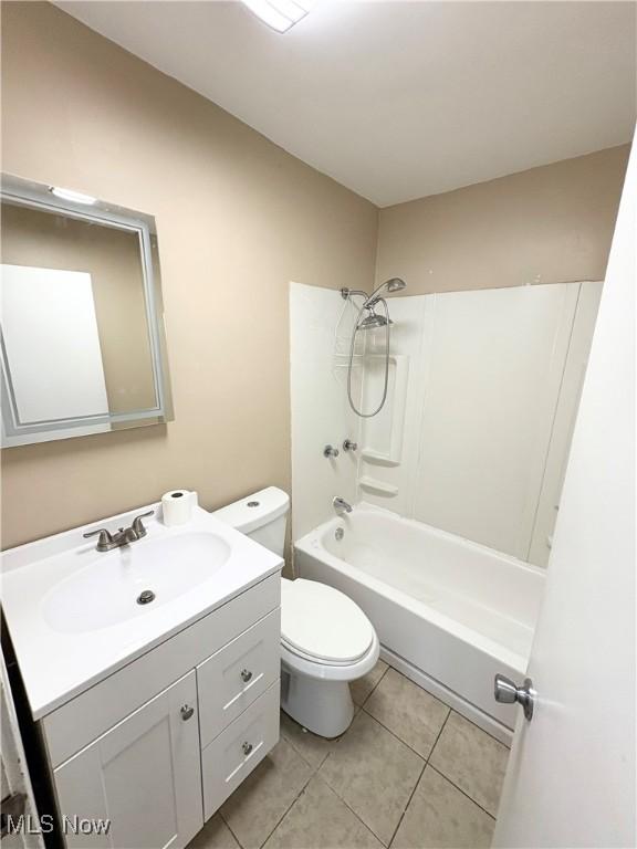 full bathroom featuring toilet, vanity, tile patterned floors, and  shower combination