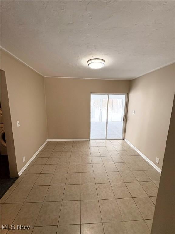 tiled empty room with a textured ceiling