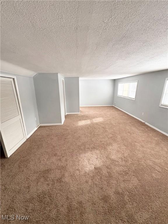 basement featuring carpet flooring and a textured ceiling