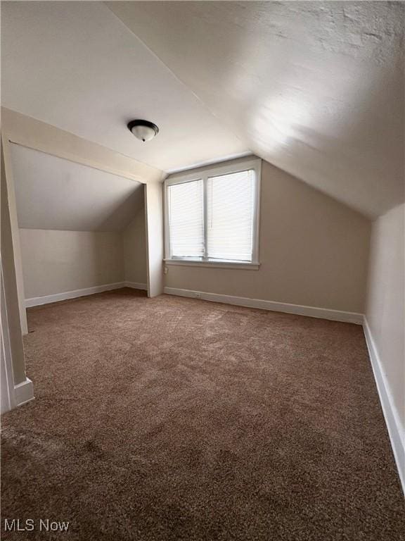 bonus room featuring vaulted ceiling and carpet