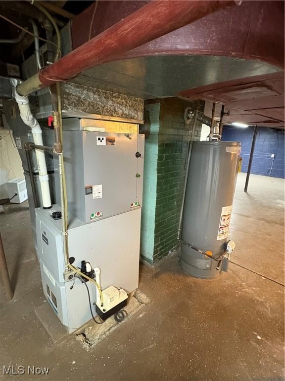 utility room featuring heating unit and gas water heater