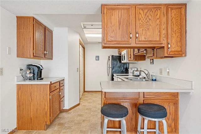 kitchen with range, kitchen peninsula, sink, and a breakfast bar area