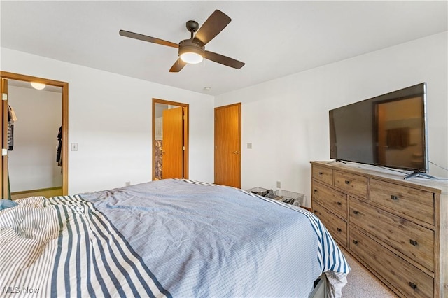 carpeted bedroom with ceiling fan and a closet