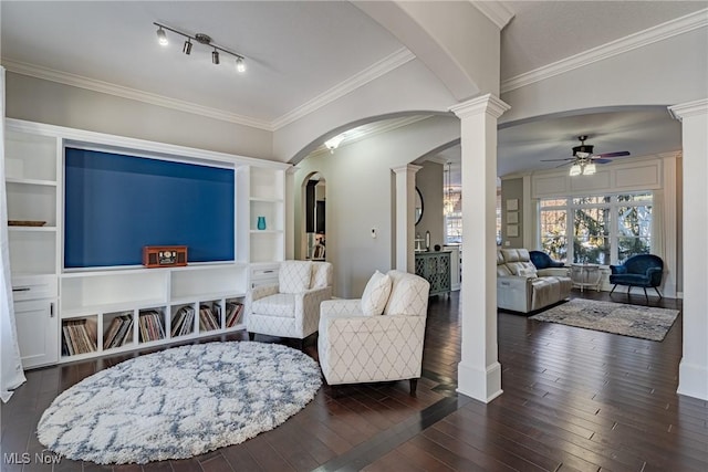 sitting room featuring ornamental molding, dark wood-type flooring, decorative columns, and ceiling fan