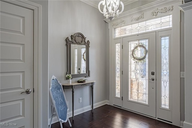 foyer featuring ornamental molding, dark hardwood / wood-style floors, and a notable chandelier