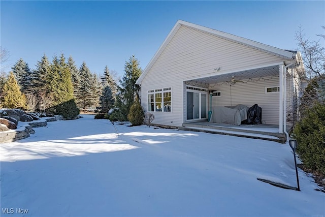 view of snow covered back of property