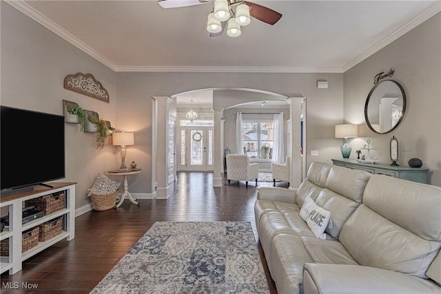 living room featuring ceiling fan, ornamental molding, dark hardwood / wood-style flooring, and decorative columns