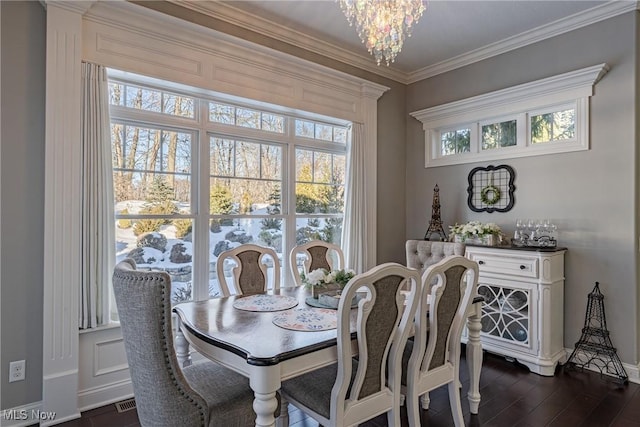 dining room with ornamental molding, dark wood-type flooring, and a chandelier