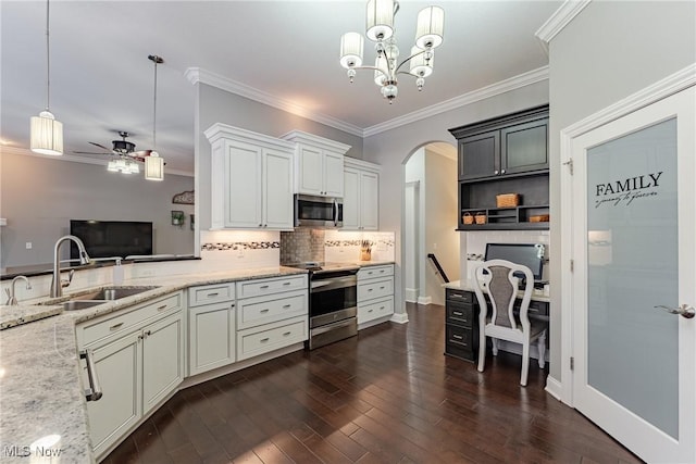 kitchen featuring pendant lighting, sink, appliances with stainless steel finishes, dark hardwood / wood-style floors, and light stone counters