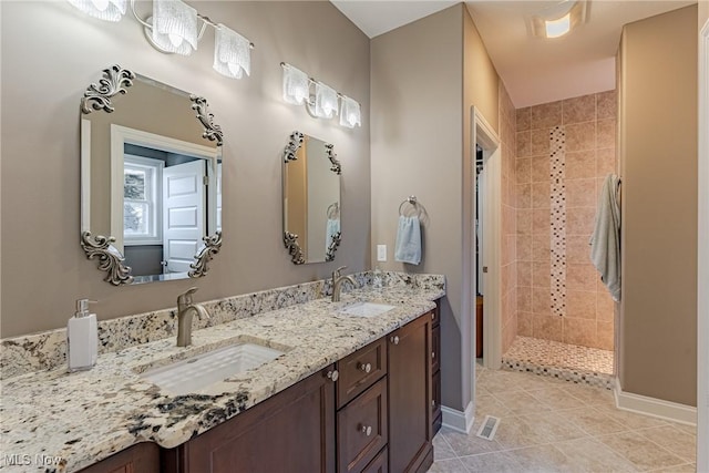 bathroom with vanity, tile patterned flooring, and a tile shower