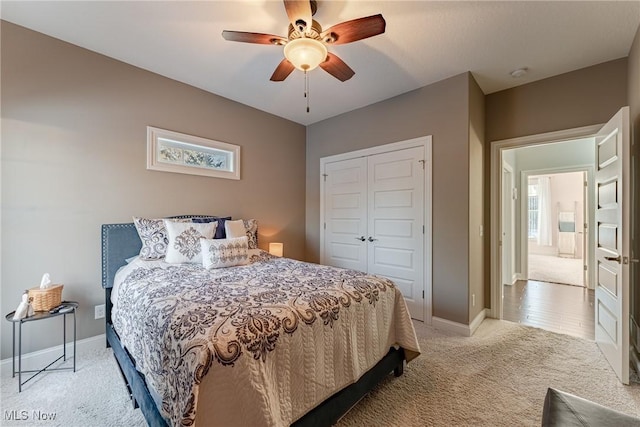 carpeted bedroom with ceiling fan and a closet