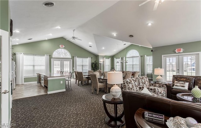 carpeted living room with vaulted ceiling, plenty of natural light, and french doors