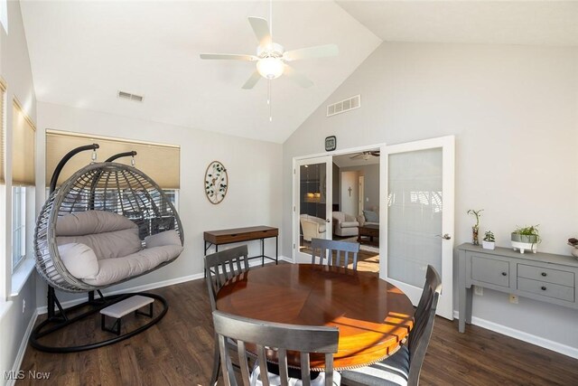 dining area featuring dark wood-type flooring, high vaulted ceiling, and ceiling fan