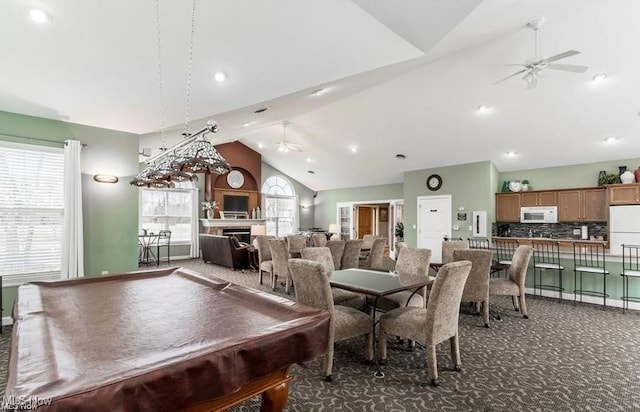 rec room with high vaulted ceiling, dark carpet, and ceiling fan